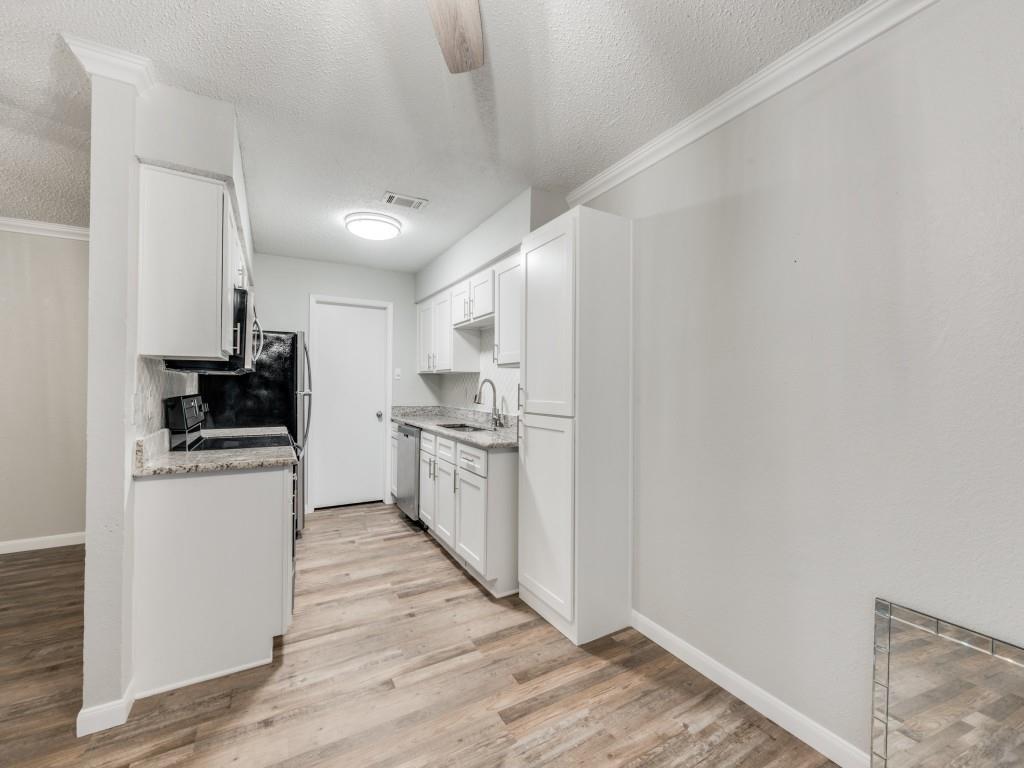 649 Timberline Drive Hurst, TX 76053 - Photo 17 of 29 a kitchen with white cabinets and appliances