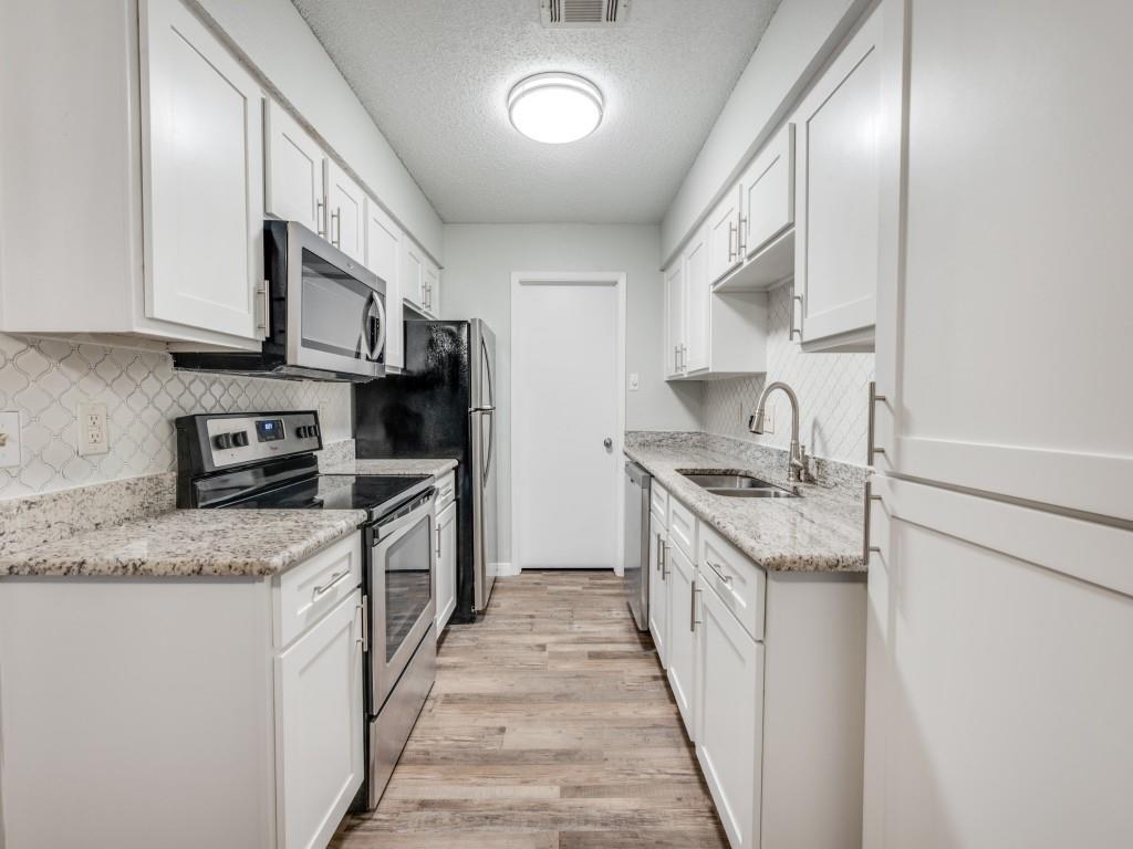 649 Timberline Drive Hurst, TX 76053 - Photo 18 of 29 a kitchen with stainless steel appliances granite countertop a stove top oven a sink and dishwasher
