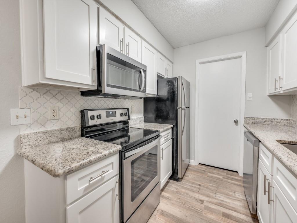 649 Timberline Drive Hurst, TX 76053 - Photo 19 of 29 a kitchen with granite countertop a sink stove and refrigerator