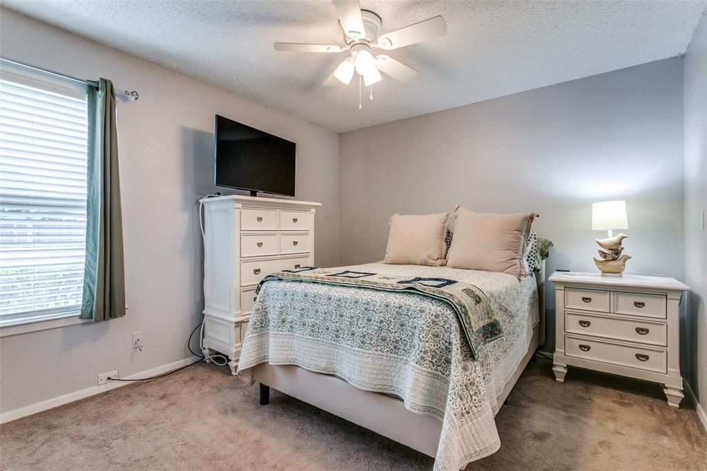 649 Timberline Drive Hurst, TX 76053 - Photo 23 of 29 a bedroom with a bed and a flat tv screen on dresser