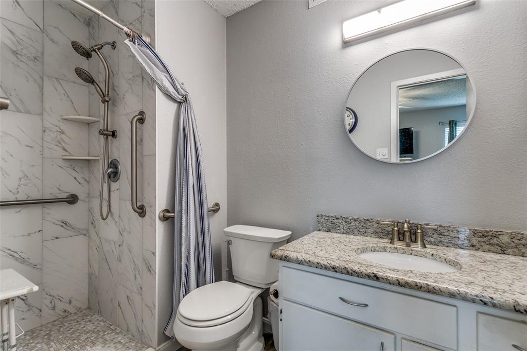 649 Timberline Drive Hurst, TX 76053 - Photo 24 of 29 a bathroom with a granite countertop toilet sink and mirror