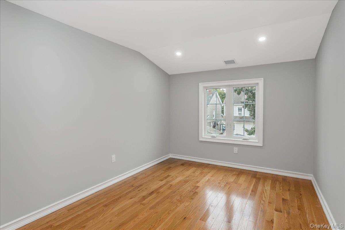 243-36 Caney Road Queens, NY 11422 - Photo 24 of 30 Unfurnished room featuring light wood-type flooring, recessed lighting, and vaulted ceiling