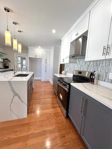 a kitchen with stainless steel appliances a sink a stove top oven a counter space and cabinets