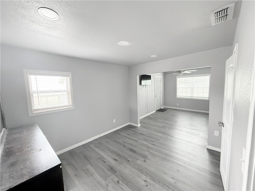 9047 County Road 471 Mathis, TX 78368 - Photo 14 of 21 an empty room with wooden floor and windows