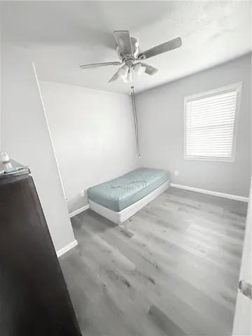 an empty room with a ceiling fan and window