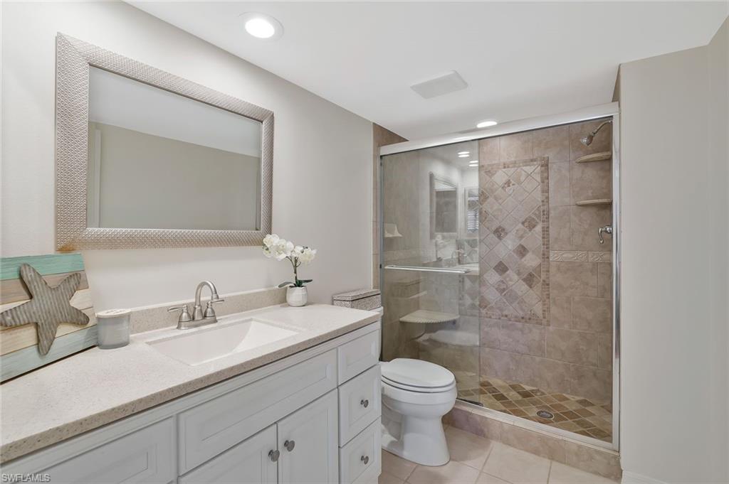601 Augusta Boulevard, Unit 6014 Naples, FL 34113 - Photo 13 of 31 a bathroom with a shower sink vanity mirror and toilet