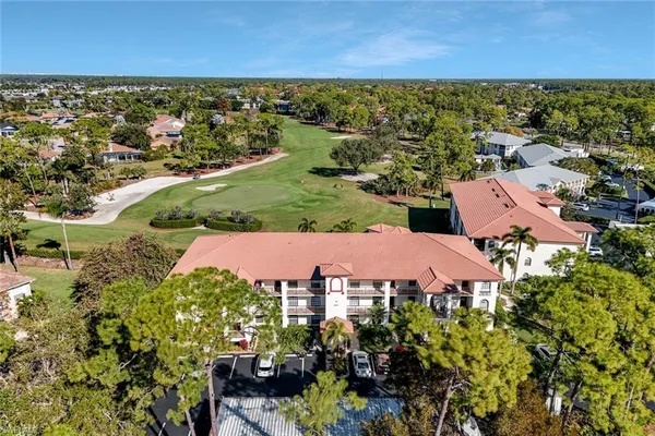 an aerial view of residential houses with outdoor space and trees