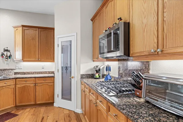 a kitchen with granite countertop a sink stove and refrigerator