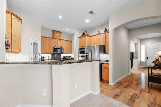 a kitchen with stainless steel appliances granite countertop a sink stove and cabinets