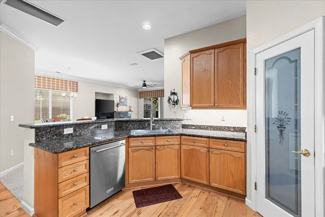 a kitchen with granite countertop a refrigerator and a stove top oven