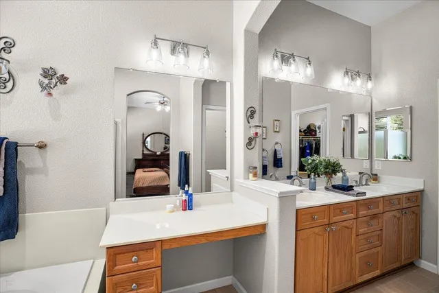 a bathroom with a tub sink and mirror