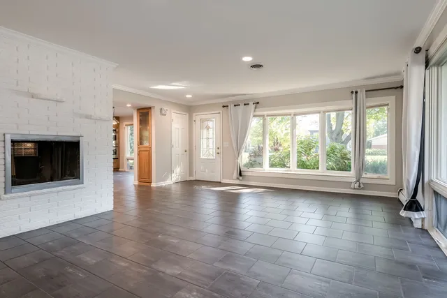 a view of an empty room with a fireplace and a large window