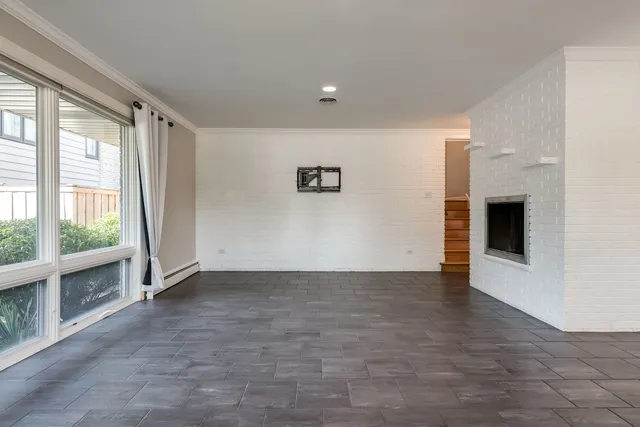 a view of an empty room with a fireplace and a window