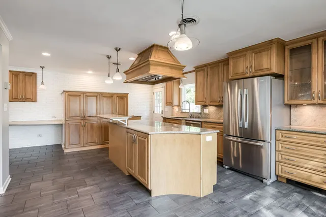 a kitchen with granite countertop a refrigerator and a sink