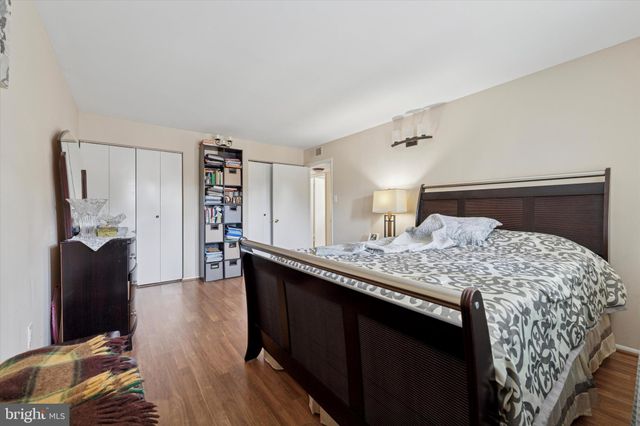 a bedroom with a bed and a large mirror on the dresser