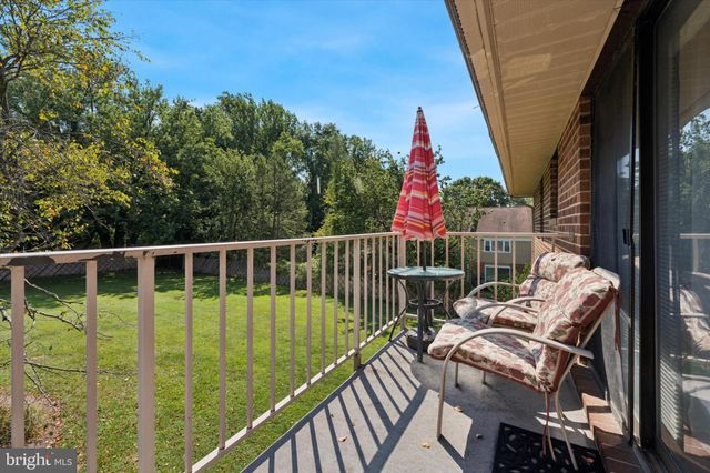 a view of a balcony with two chairs and wooden fence