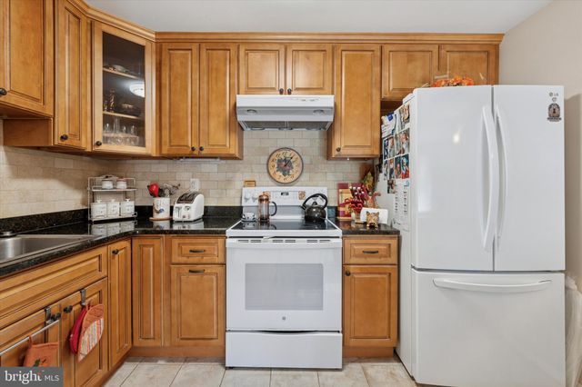 a kitchen with stainless steel appliances granite countertop a refrigerator stove and sink