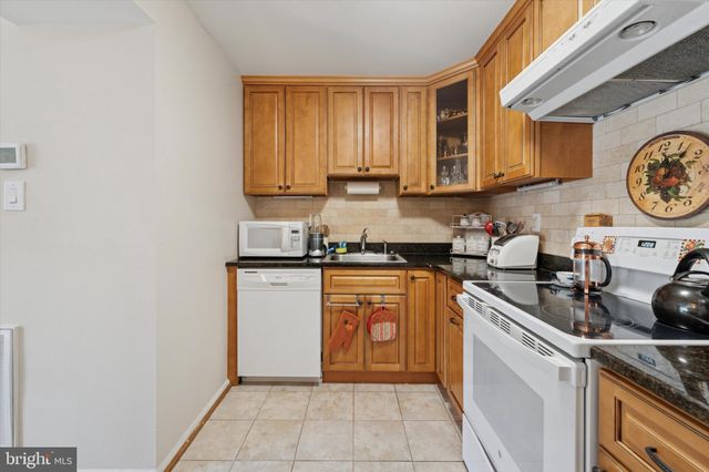 a kitchen with stainless steel appliances granite countertop a stove a sink and cabinets