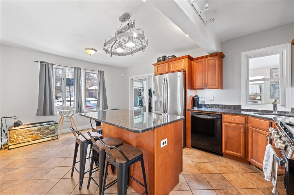 28 Barnard Road Worcester, MA 01605 - Photo 7 of 29 a kitchen with stainless steel appliances granite countertop a stove top oven cabinets a dining table and chairs