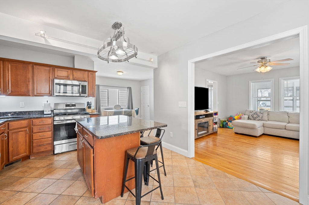 28 Barnard Road Worcester, MA 01605 - Photo 8 of 29 a very nice looking kitchen with granite countertop a stove top oven a sink dishwasher a dining table and chairs with wooden floor