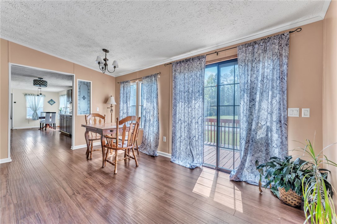 137 East Reedy Fork Road Seneca, SC 29678 - Photo 12 of 28 Warm wood floors and a charming chandelier define this inviting dining space.