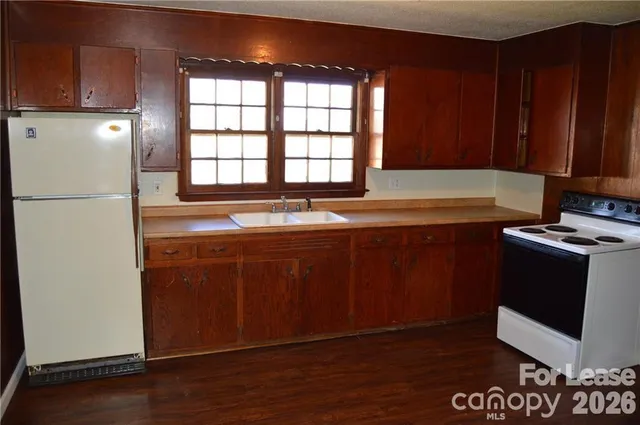 a kitchen with stainless steel appliances granite countertop a refrigerator a sink and a cabinets