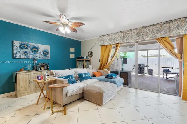 a living room with furniture a flat screen tv and a large window