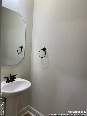 a bathroom with a sink a light fixture and a mirror