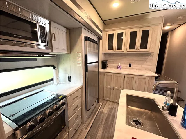 a kitchen with stainless steel appliances a stove a sink and a microwave