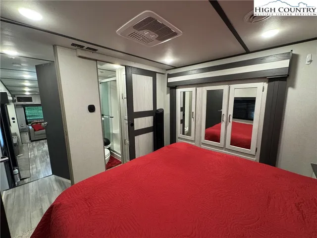 a bedroom with a large bed and a large mirror