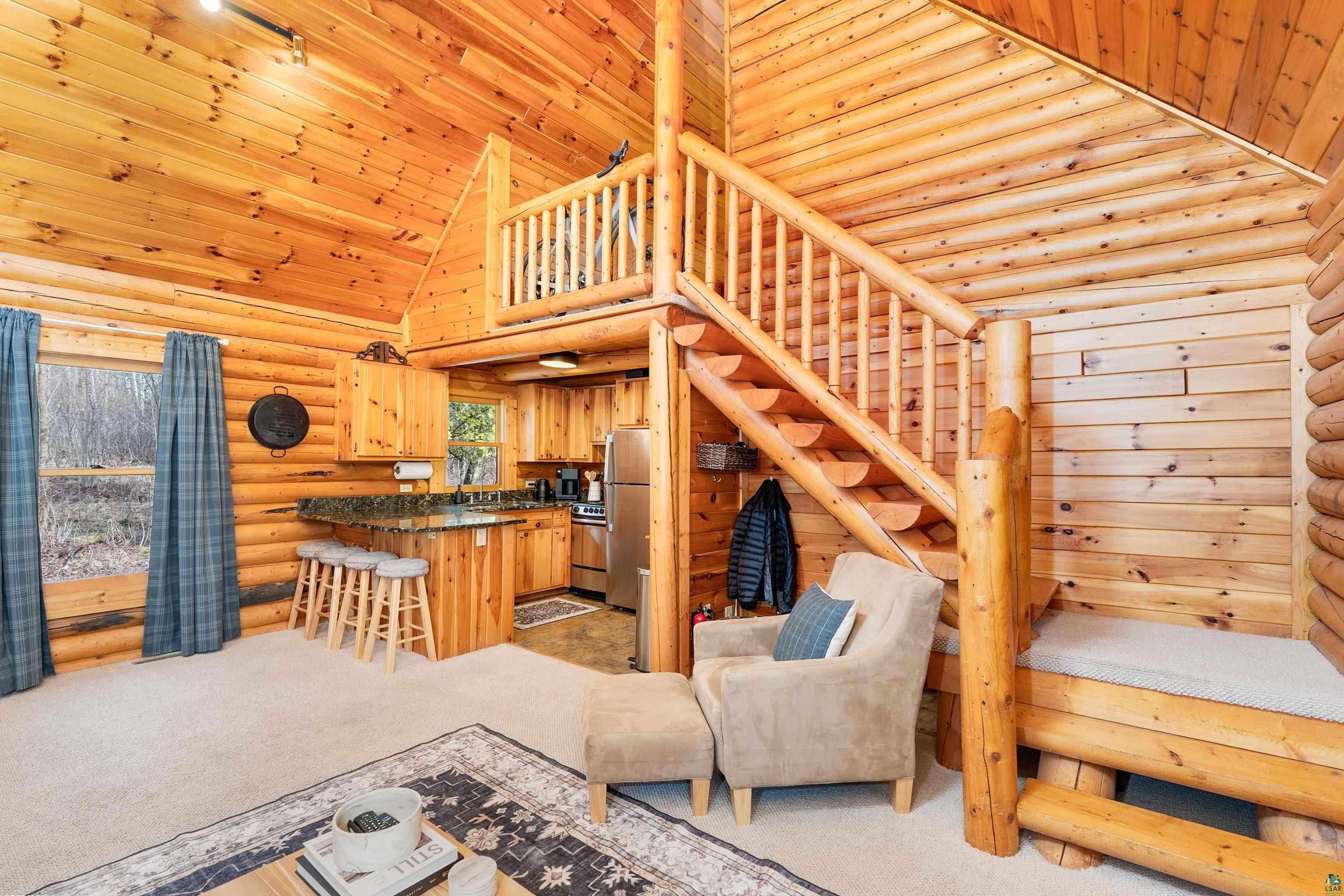 2659 Ridgeview Drive Two Harbors, MN 55616 - Photo 15 of 56 Open-concept living space featuring wood-finish walls and ceilings, a wooden staircase, and a loft area