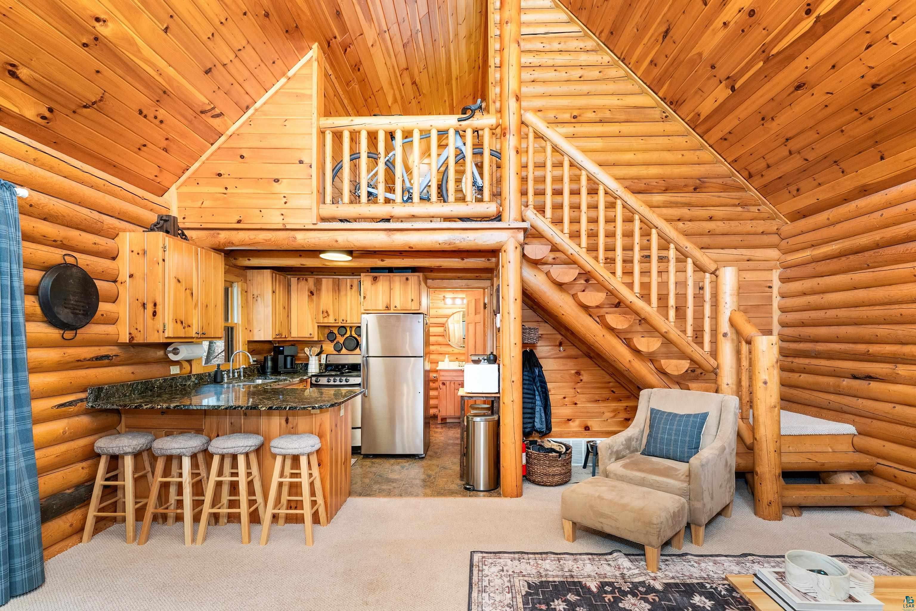 2659 Ridgeview Drive Two Harbors, MN 55616 - Photo 16 of 56 Vaulted ceiling with wood-paneled finish, a log construction interior, and a kitchen featuring a granite-style countertop
