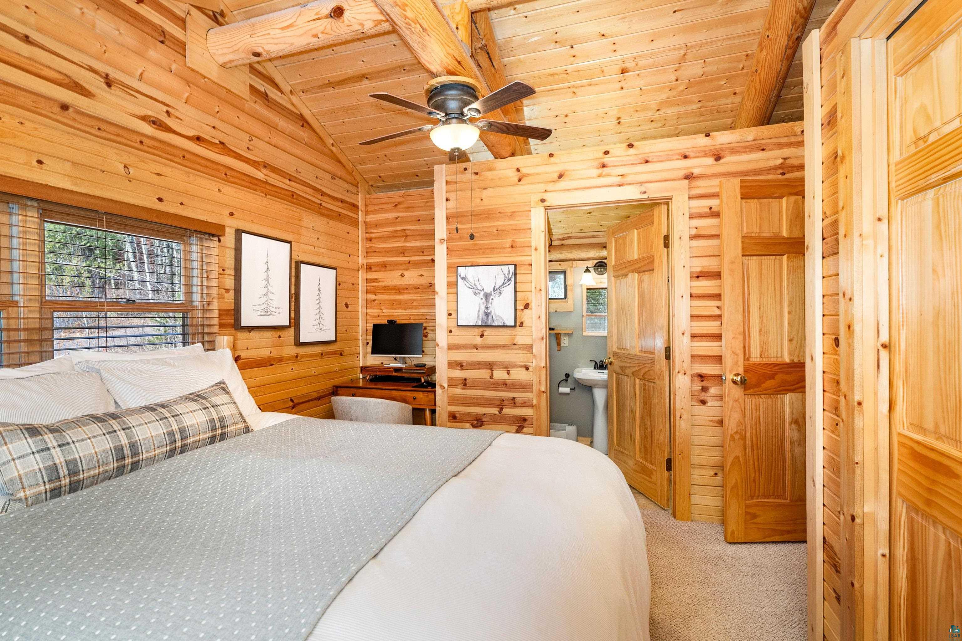 2659 Ridgeview Drive Two Harbors, MN 55616 - Photo 25 of 56 Wood-paneled room featuring a vaulted ceiling with exposed wooden beams, a ceiling fan with integrated lighting, and carpet flooring