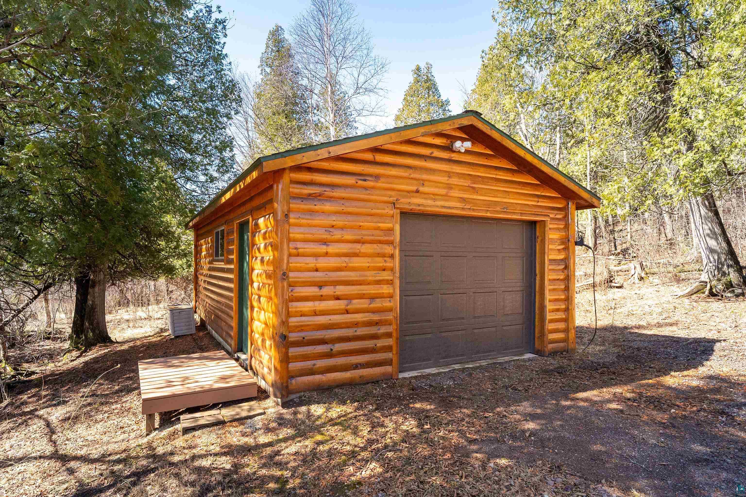 2659 Ridgeview Drive Two Harbors, MN 55616 - Photo 48 of 56 Log cabin-style detached garage with a dark brown overhead door, a pitched roof, and exterior lighting