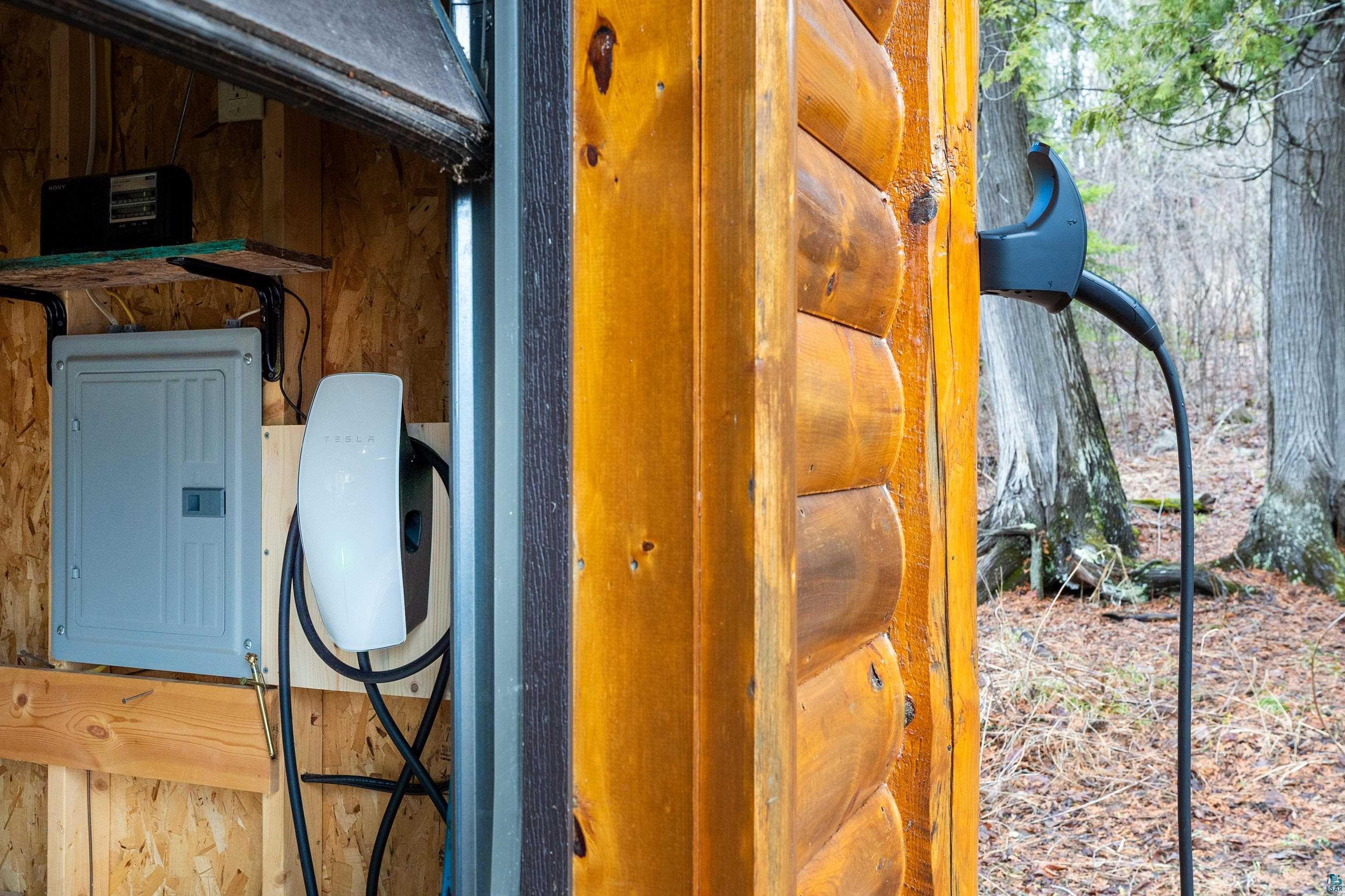 2659 Ridgeview Drive Two Harbors, MN 55616 - Photo 51 of 56 Electric vehicle charging station with a Tesla wall connector and an adjacent electrical panel