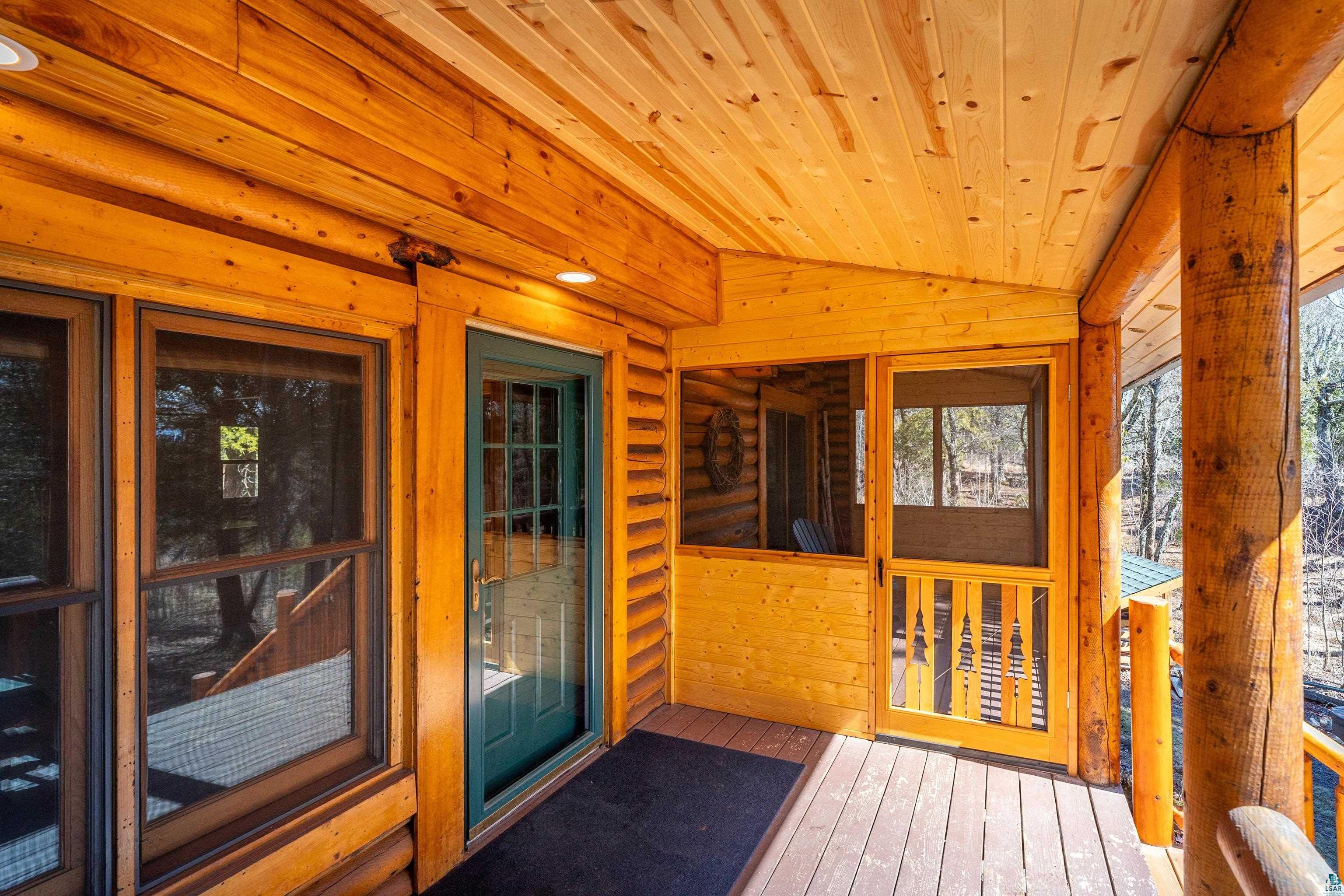 2659 Ridgeview Drive Two Harbors, MN 55616 - Photo 8 of 56 Wood-finish porch featuring recessed lighting, a screened entry door, a solid panel door, and a log column