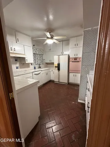 a kitchen with white cabinets and white appliances