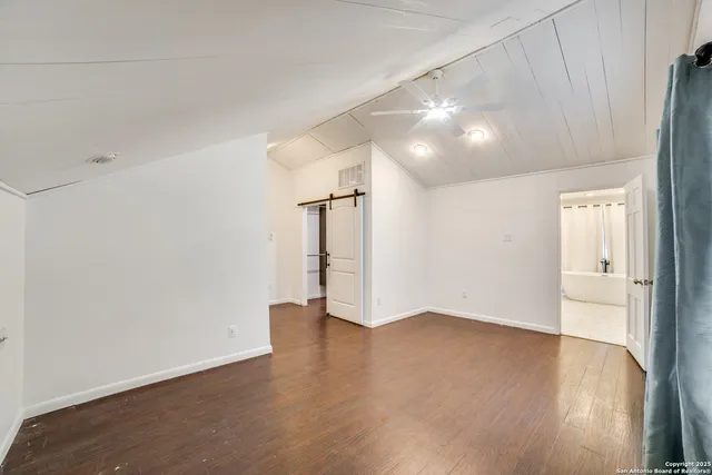 a view of an empty room with wooden floor