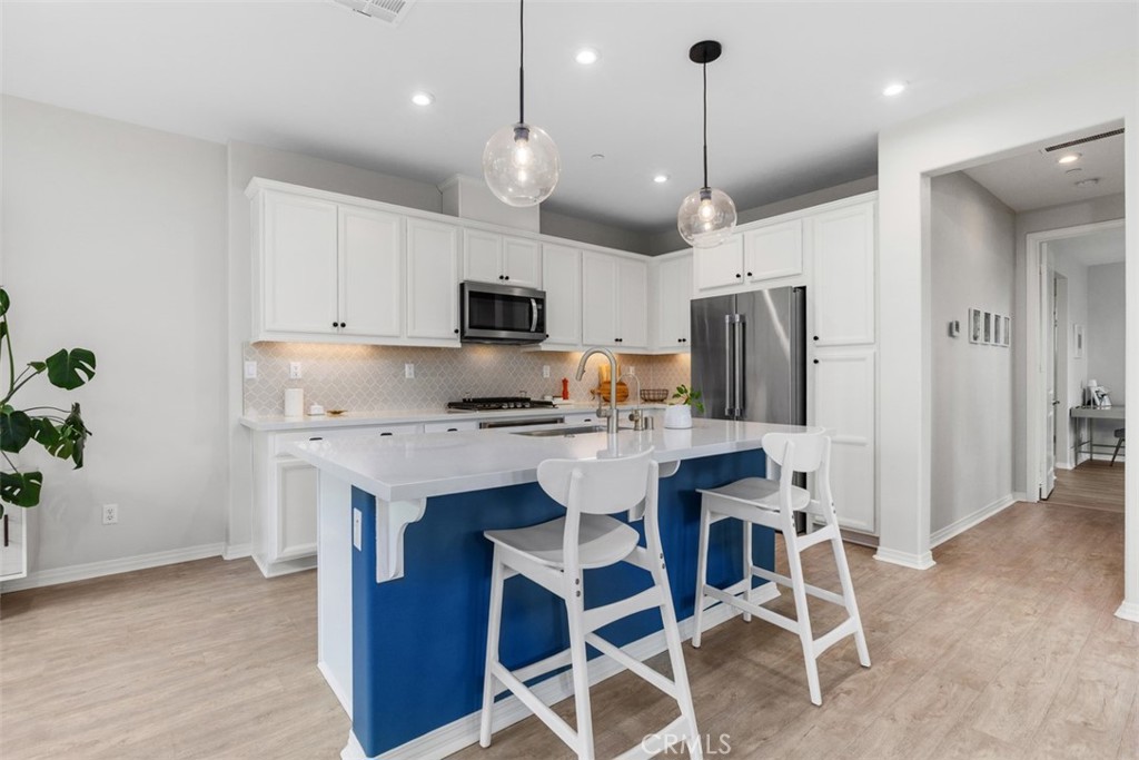 128 Natal Road Rancho Mission Viejo, CA 92694 - Photo 12 of 30 a kitchen with kitchen island white cabinets and stainless steel appliances