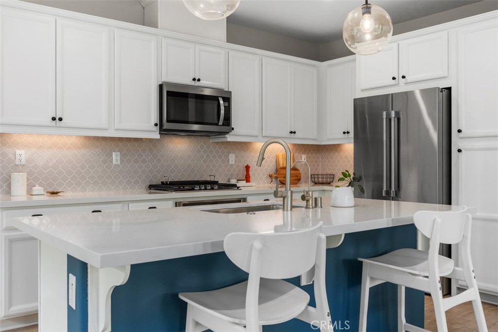 128 Natal Road Rancho Mission Viejo, CA 92694 - Photo 13 of 30 a kitchen with stainless steel appliances a stove a sink a cabinets and chairs