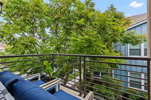 a view of a balcony with two chairs and a potted plant