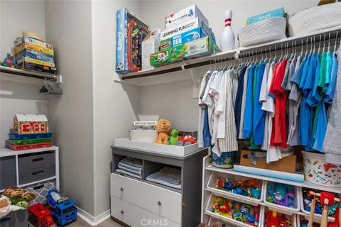 a view of walk in closet with clothes and shoes
