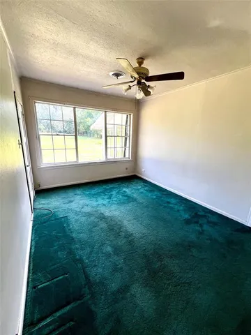 a view of room with window and a ceiling fan