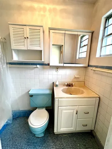 a bathroom with a sink toilet and window