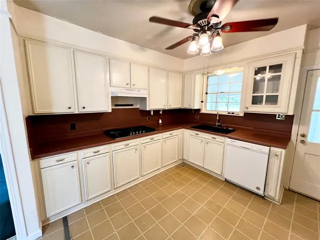 a white kitchen with a sink and a cabinets