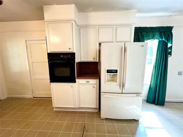 a white refrigerator freezer and a stove sitting inside of a kitchen