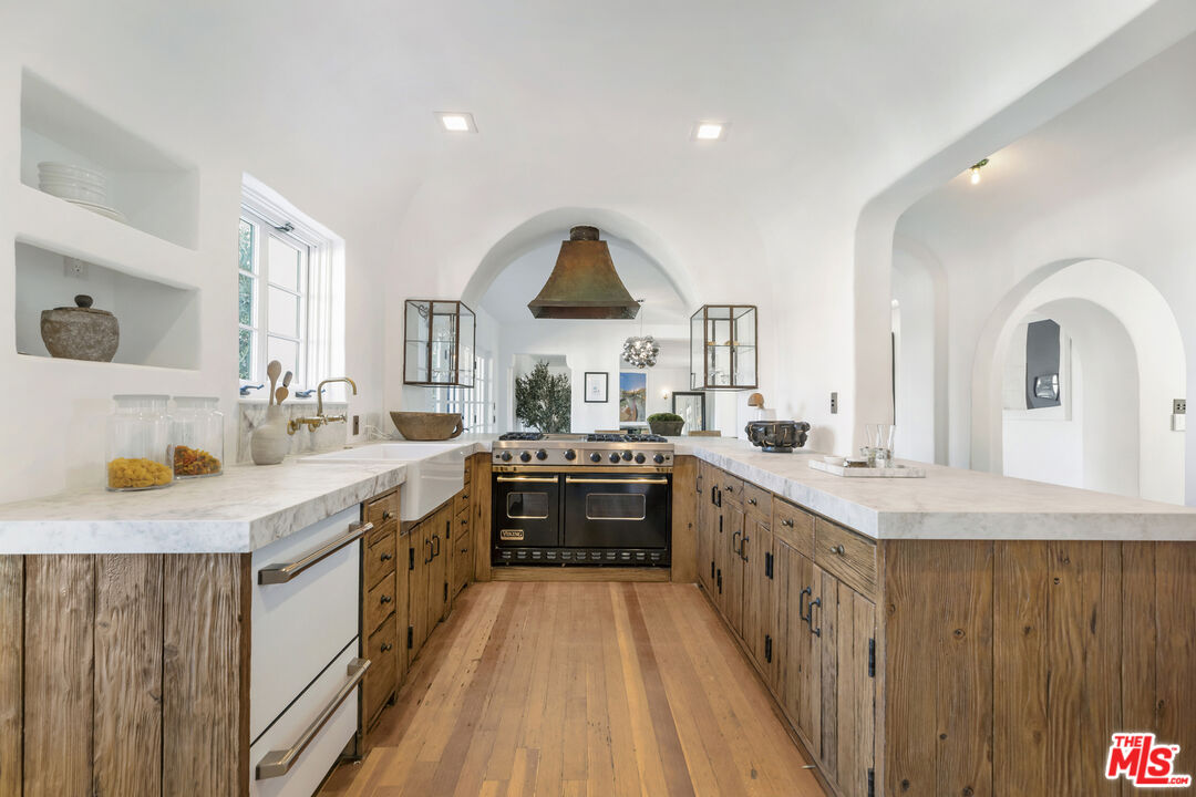 4565 Dundee Drive Los Angeles, CA 90027 - Photo 13 of 42 a kitchen with kitchen island granite countertop a sink a counter top space and cabinets