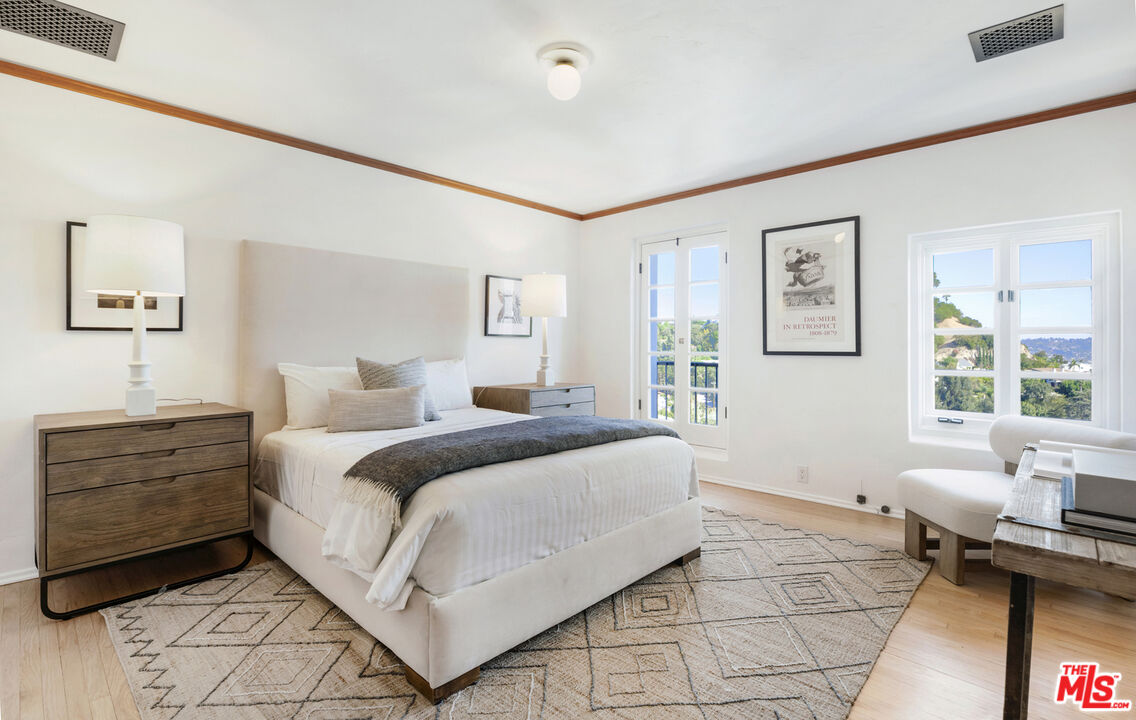 4565 Dundee Drive Los Angeles, CA 90027 - Photo 22 of 42 a spacious bedroom with a bed and wooden floor