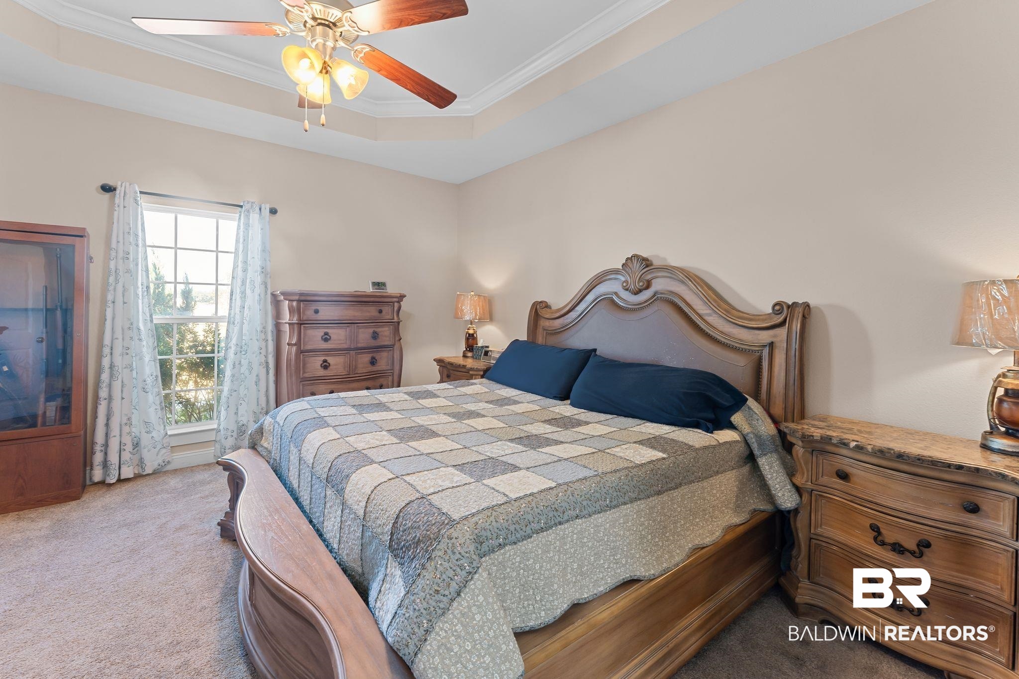 28980 Comstock Road Elberta, AL 36530 - Photo 16 of 38 Bedroom with a tray ceiling, carpet flooring, ornamental molding, and a ceiling fan