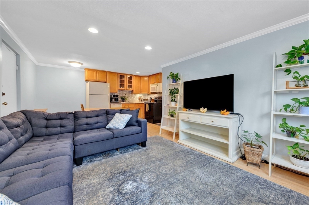 588 Main Street, Unit 3C Stoneham, MA 02180 - Photo 12 of 24 a living room with furniture and a flat screen tv